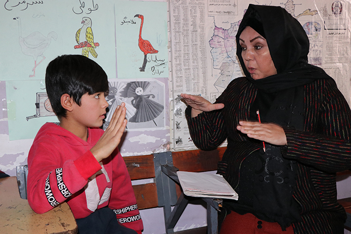 Shahla talar teckenspråk med 11-åriga Fayaz.