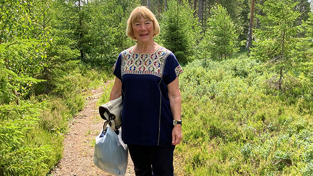 Margareta på en stig i grönskande sommarlamdskap.