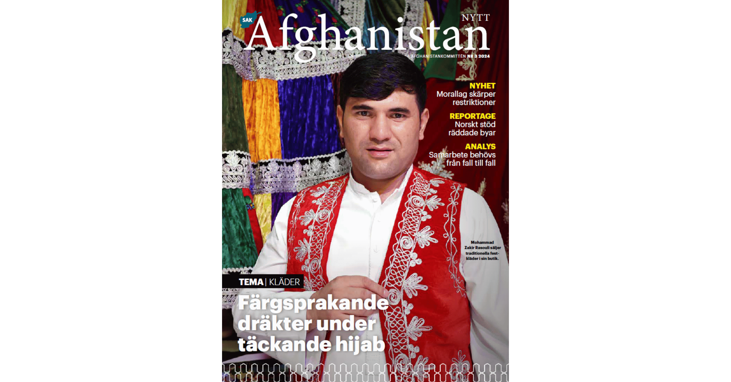 Bilden visar ett tidningsomslag till tidningen Afghanistan-Nytt. På bilden syns en man klädd i vita kläder och en röd, broderad väst. Han tittar in i kameran och bakom honom syns tyger i olika färger.