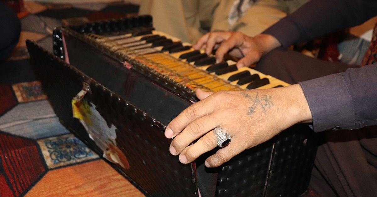 En hand syns som spelar harmonium.